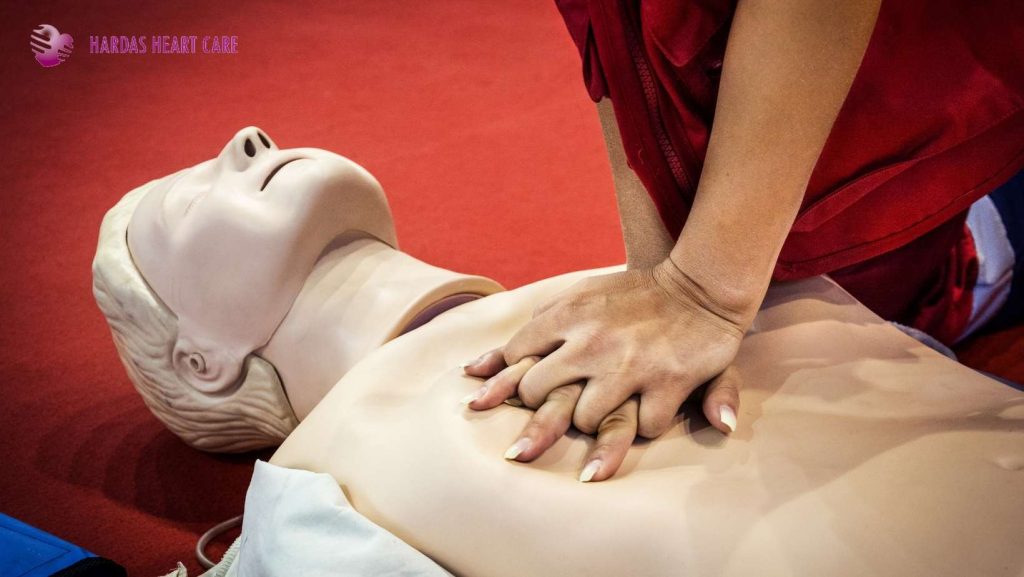 Person performing CPR on a mannequin to demonstrate life-saving chest compressions during cardiac arrest training.